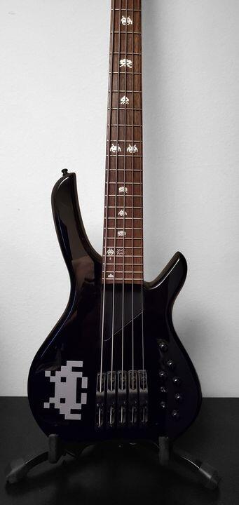 A black Willcox Lightwave Saber 5 bass guitar with Space Invaders theme